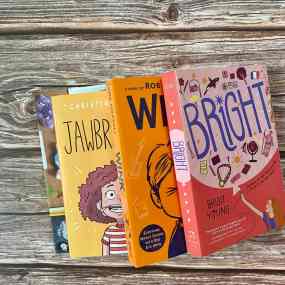 four middle grade books for 7th grade book clubs lay stacked on each other