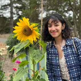 indian-american girl stands by a sunflower