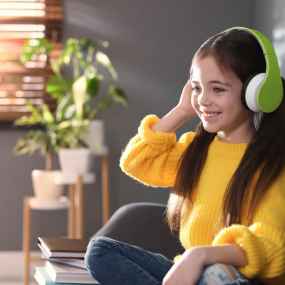cute white girl with headphones on listening to an audiobook for tweens