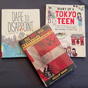 3 middle school biography books lay over each other