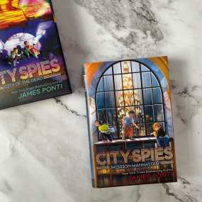 two of the city spies books like on a marble countertop