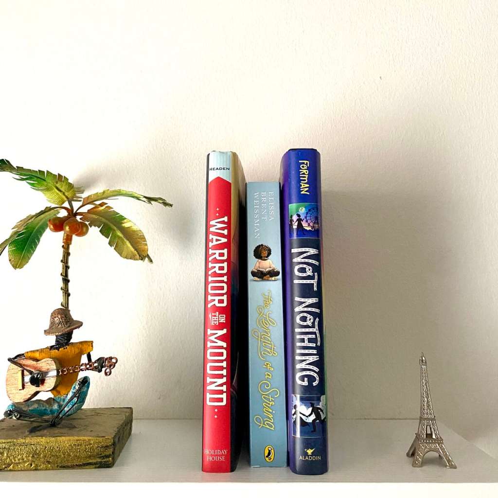 3 historical fiction books for 7th graders on a white floating shelf