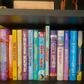 a row of middle grade books stacked on a shelf