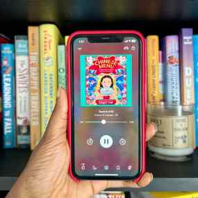 a picture of a hand holding a phone with the audiobook chinese menu on screen