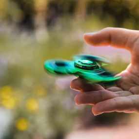 person playing with green fidget spinner