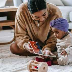 mother and baby girl reading a book